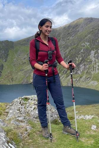Rehna Yaseen stood by a lake in the sun, in the Lake District