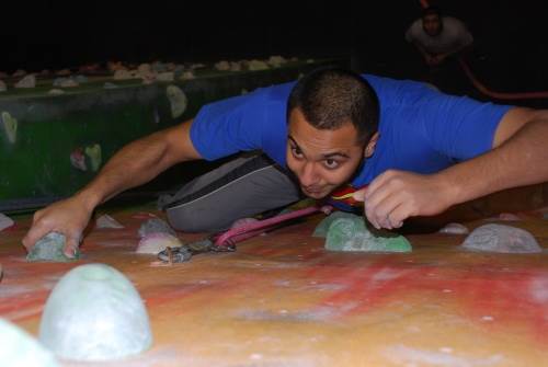 Man lead climbing looking up to the next hold